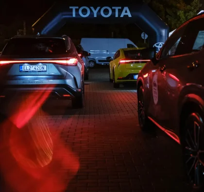 Vozy Toyota pod nasvíceným obloukem